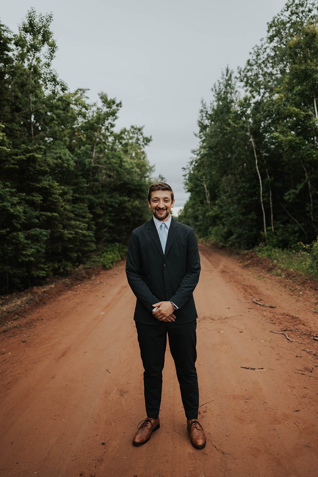Levi Ewald standing on a red dirt road on Prince Edward Island